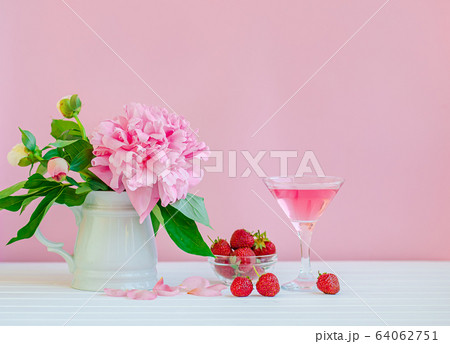 Pink peonies in a crystal vase on a pink wood Pink peonies in a crystal vase on a pink wood 64062751