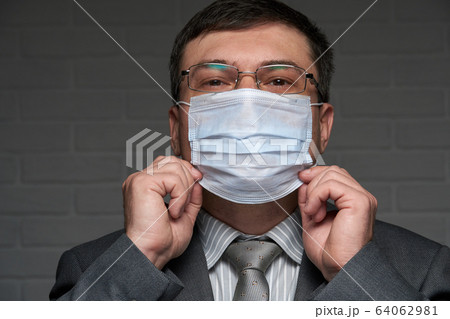 a man puts a mask on his face for antivirus 64062981