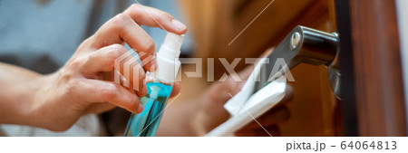 woman hand disinfecting the door handle by woman hand disinfecting the door handle by 64064813