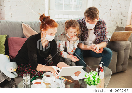 Caucasian family in protective masks and gloves isolated at home with coronavirus symptoms, treatment 64066248