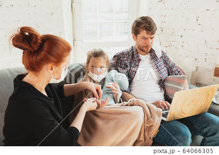 Caucasian family in protective masks and gloves isolated at home with coronavirus symptoms, treatment 64066305