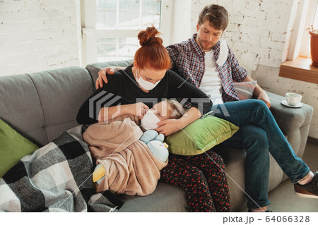 Caucasian family in protective masks and gloves isolated at home with coronavirus symptoms, treatment Caucasian family in protective masks and gloves isolated at home with coronavirus symptoms, treatment 64066328