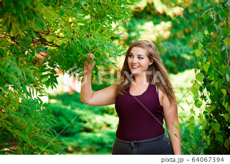Pretty young woman walking on the city street. Casual fashion, plus size model. xxl women on nature. 64067394