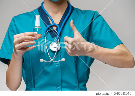 medical doctor nurse wearing protective mask - holding bottle of sanitizing spray or gel medical doctor nurse wearing protective mask - holding bottle of sanitizing spray or gel 64068143