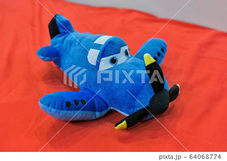 Soft toy blue airplane on red closeup Soft toy blue airplane on red closeup 64068774