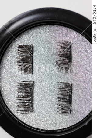 Artificial eyelashes on a magnet on a white 64070154