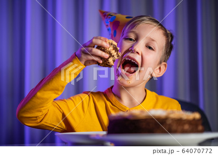 Happy child takes a piece of celebration cake and 64070772