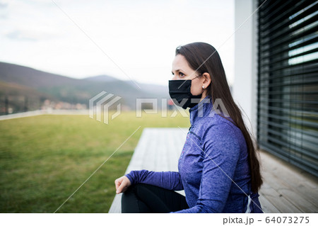 Woman with face masks outdoors at home, Corona virus and quarantine concept. 64073275