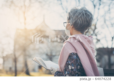 Senior woman praying for end of coronavirus crisis 64074228