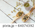 Natural organic herbal green tea in wooden spoons. 64074392