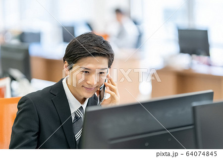 ビジネス　オフィス　スマートフォン　デスクワーク 64074845