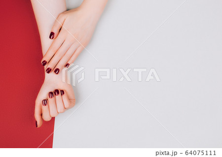 Red manicure on beautiful accurate woman's hands. 64075111