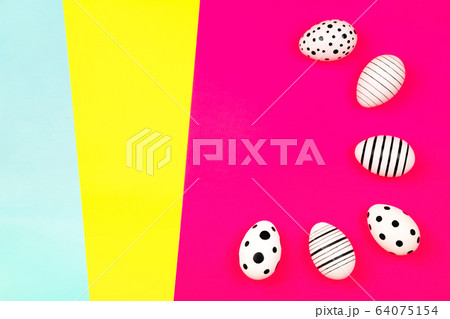 Different graphic hand-painted eggs on bright pink background. 64075154