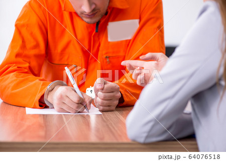 Young man meeting with advocate in pre-trial detention 64076518