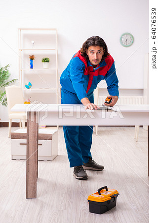 Young male carpenter working indoors Young male carpenter working indoors 64076539