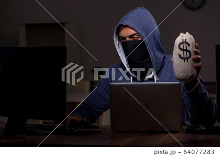 Male hacker hacking security firewall late in office Male hacker hacking security firewall late in office 64077283