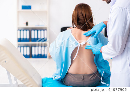 Injured young woman visiting young male doctor Injured young woman visiting young male doctor 64077906