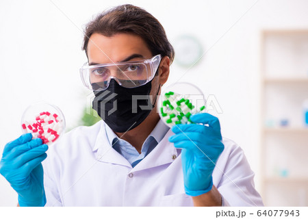 Young male chemist in drug synthesis concept Young male chemist in drug synthesis concept 64077943
