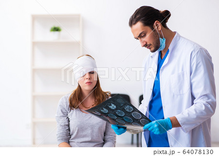 Young head injured woman visiting young male doctor Young head injured woman visiting young male doctor 64078130