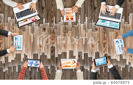 Top view of businesspeople sitting at table and using gadgets 64078975