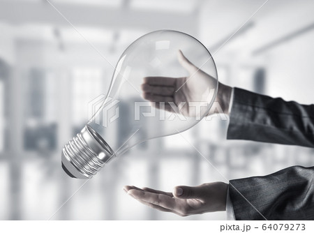 Good idea concept by means of lightbulb in hands. Good idea concept by means of lightbulb in hands. 64079273