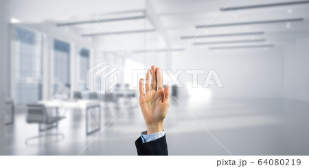 Choosing gesture of businessperson in elegant modern interior in sunshine light 64080219