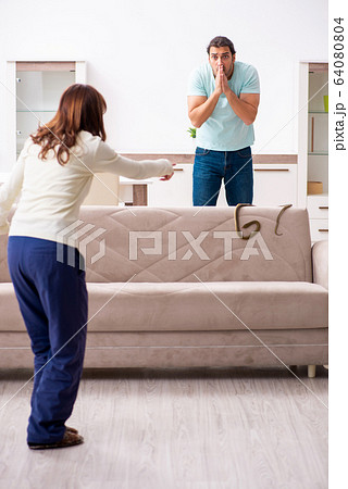 Young couple and snake in the flat 64080804