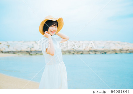 海辺を歩く若い女性　 64081342
