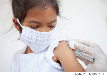 Doctor injecting vaccination on asian child girl arm Doctor injecting vaccination on asian child girl arm 64083404
