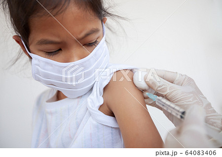 Doctor injecting vaccination on asian child girl arm Doctor injecting vaccination on asian child girl arm 64083406