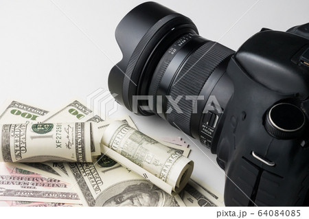A black digital camera on banknotes with white background. 64084085