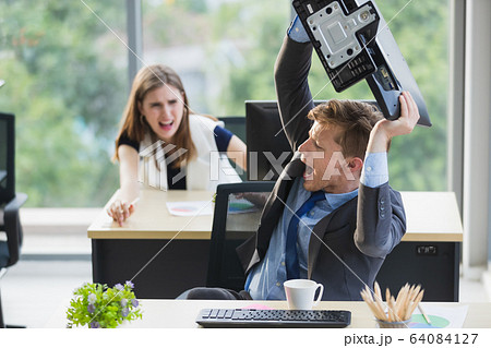 Man throwing computer screen at female co-worker.. 64084127