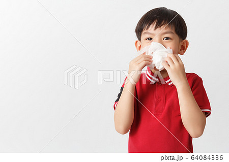 Little asian boy holding a tissue and blow his 64084336