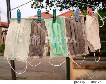 Dry mask Many masks for protection against Covid-19 were washed and hung for drying. To reuse it again because the mask was in short supply or expensive during the crisis. Selective focus 64084740