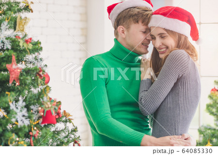 Couple celebrating Christmas. Man hugging woman.. Couple celebrating Christmas. Man hugging woman.. 64085330
