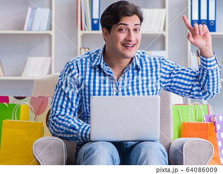 Young man after excessive shopping at home 64086009