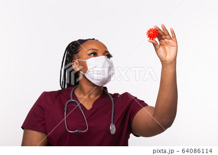 Covid-19, Vaccine development , outbreak and medicine concept - Doctor in medical protective mask holding a model of coronavirus. Covid-19, Vaccine development , outbreak and medicine concept - Doctor in medical protective mask holding a model of coronavirus. 64086114