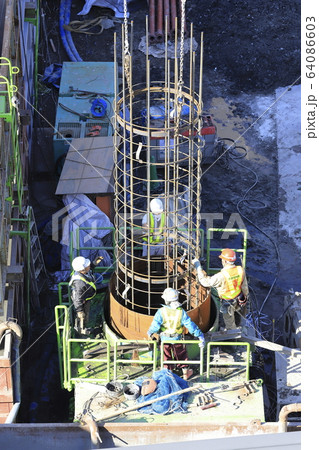 建築現場　基礎工事　ガイドパイプと鉄筋連結作業　 64086603