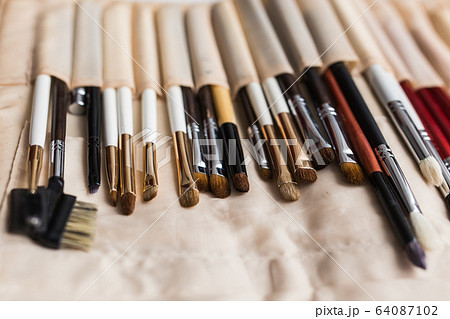 Makeup, beauty and cosmetics concept - Set of make-up brushes in a light case. 64087102