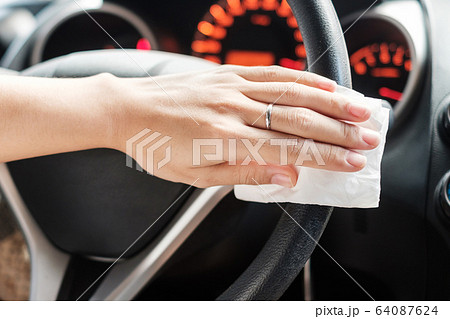 woman hand cleaning on steering wheel in his car, 64087624