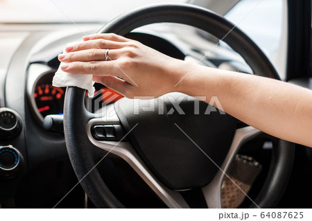woman hand cleaning on steering wheel in his car, woman hand cleaning on steering wheel in his car, 64087625