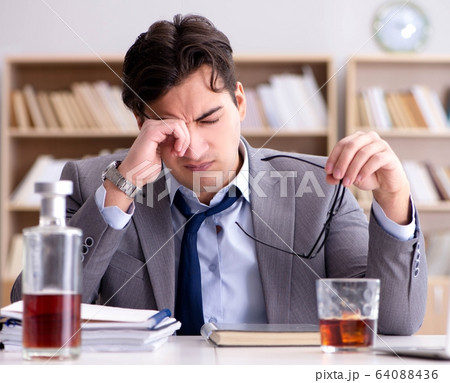Young businessman drinking from stress Young businessman drinking from stress 64088436