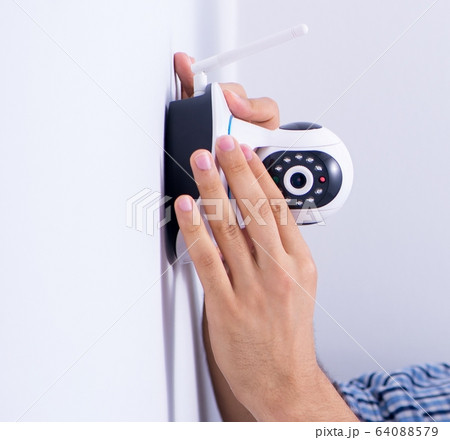 Man installing surveillance CCTV cameras at home 64088579