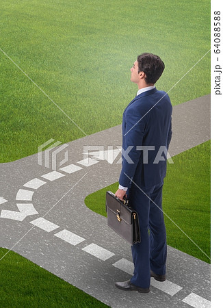Young businessman at crossroads in uncertainty concept 64088588