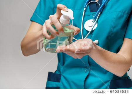 medical doctor nurse wearing protective mask - holding sanitizing spray or gel or liquid soap medical doctor nurse wearing protective mask - holding sanitizing spray or gel or liquid soap 64088638