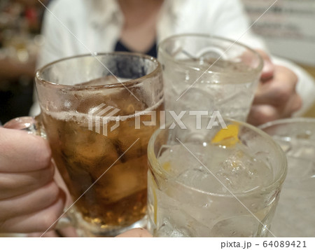 4人でウーロンハイとレモン酎ハイのグラスで乾杯をする 4人でウーロンハイとレモン酎ハイのグラスで乾杯をする 64089421