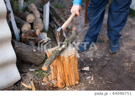 Man chopping wood in the backyard. Lumberjack cuts logs 64090751