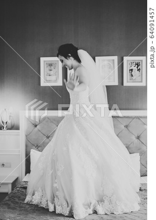 Beautiful bride wearing fashion wedding dress with feathers with luxury delight make-up and hairstyle, studio indoor photo shoot 64091457