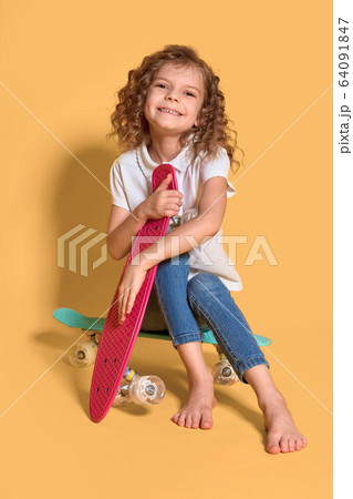 Active and happy Kid having fun with penny board, smiling face stand skateboard. Penny board cute skateboard for girls. Lets ride. Girl ride penny board yellow background. Summer vacation Active and happy Kid having fun with penny board, smiling face stand skateboard. Penny board cute skateboard for girls. Lets ride. Girl ride penny board yellow background. Summer vacation 64091847