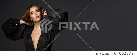 Portrait of beautiful brunette woman in black dress. Fashion photo 64092275